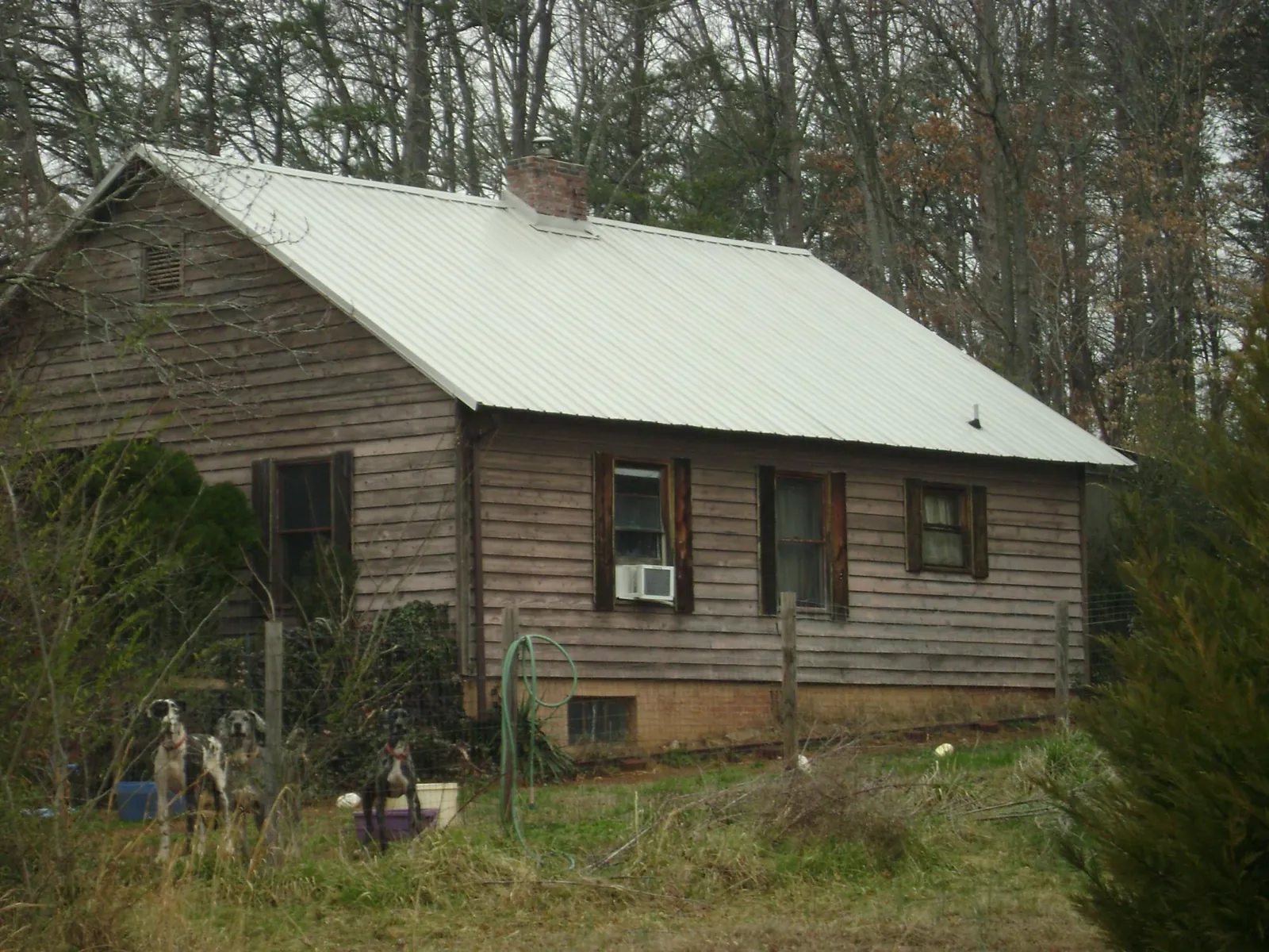 White metal roof on an old wood sided farmhouse, from a Metal Roof Installation job in Tonica